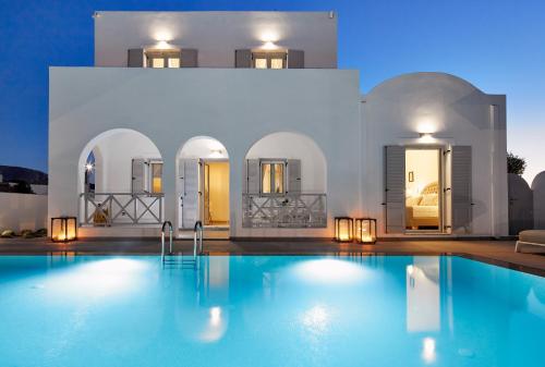 a villa with a swimming pool in front of a building at Tramonto Private Villa in Monolithos