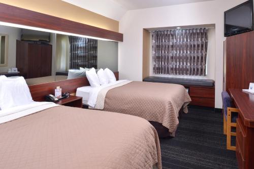 Habitación de hotel con 2 camas y TV de pantalla plana. en Americas Best Value Inn & Suites Maryville en Maryville