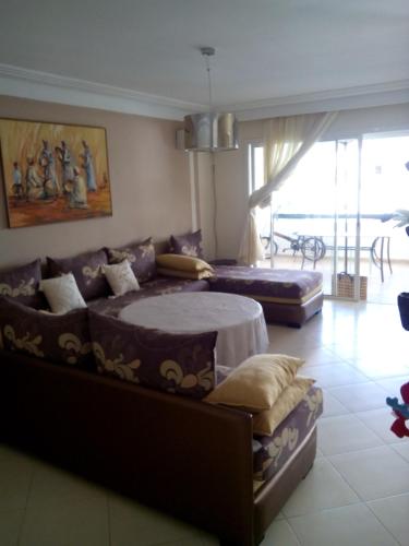 a living room with a couch and a table at location de vacance assilah marina golf in Asilah