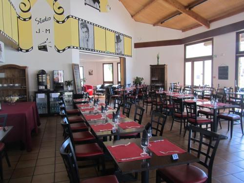 une salle à manger avec des tables, des chaises et des serviettes rouges dans l'établissement Hôtel - Restaurant Le Saint Joseph, à Saint-Éloy-les-Mines