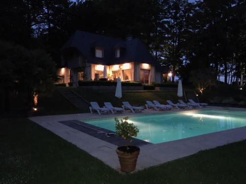 ヴィレ・シュル・メールにあるSuperbe Villa Individuelle avec Piscine et Tennis privatifsの夜間のスイミングプール付きハウス