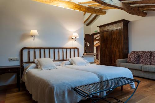 a bedroom with two beds and a couch at Casa Baquedano in Murugarren