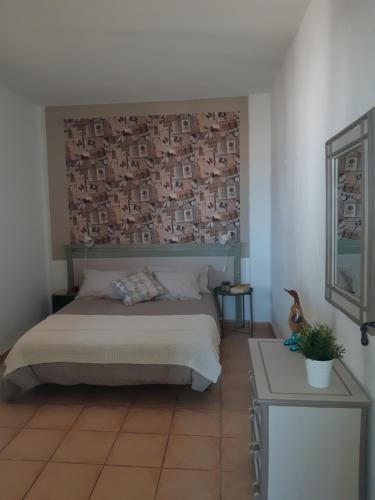 a bedroom with a bed with a picture on the wall at Tilama in Puerto del Rosario
