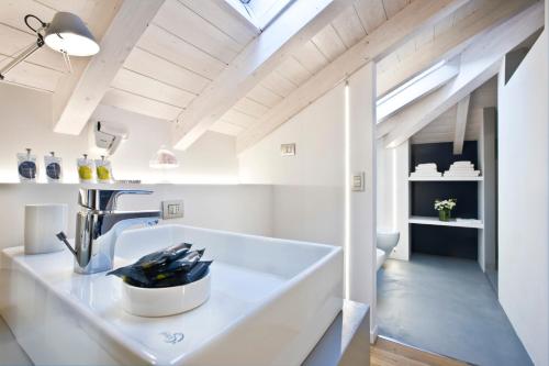 a white bathroom with a sink and a window at Manzoni 124 Bed&Relax in Esine