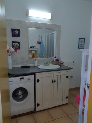 a bathroom with a sink and a washing machine at Tilama in Puerto del Rosario