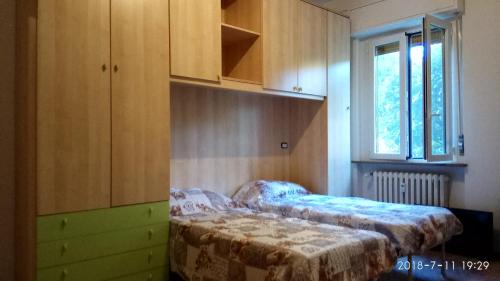 1 dormitorio con 2 camas, ventana y armarios en Bixio, en Pavia