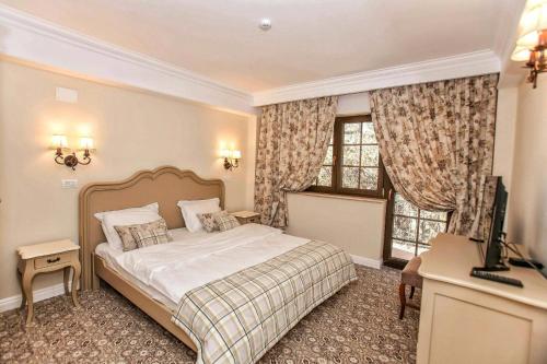 a bedroom with a bed and a television in it at PENSIUNEA DIMITRIOS Relaxare cu jacuzzi pe Valea Cernei in Băile Herculane