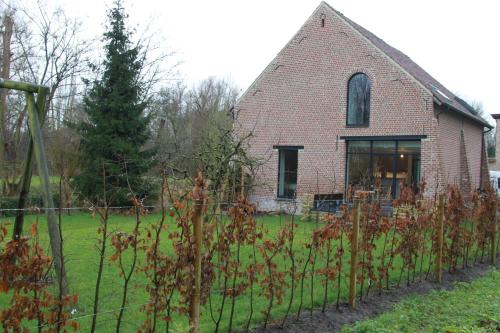 an old brick house with a fence in front of it at Logies Tommenmolen in Grimbergen