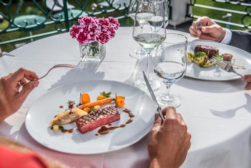 a group of people sitting around a table eating food at Relais & Châteaux Hotel Tennerhof in Kitzbühel