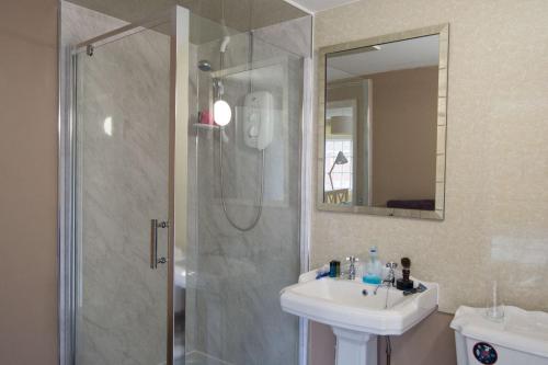 a bathroom with a shower and a sink at The Crown Aldbourne in Aldbourne