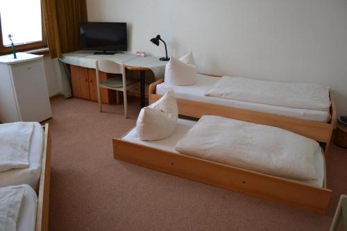 a room with three beds and a desk with a computer at Hofreit am Bierkeller in Kehl am Rhein