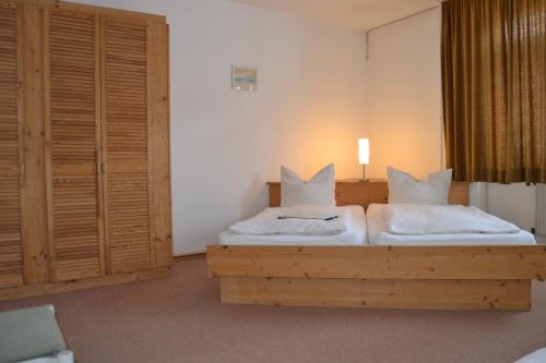 a bedroom with a wooden bed with white pillows at Hofreit am Bierkeller in Kehl am Rhein