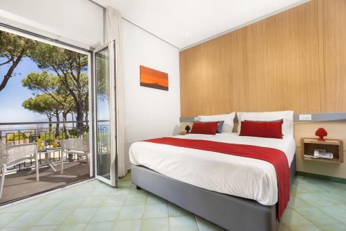 a bedroom with a large bed and a balcony at Hotel O Sole Mio in SantʼAgata sui Due Golfi