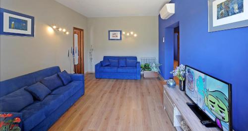 a living room with a blue couch and a tv at Casa Vacanze La Mattonara in Viterbo
