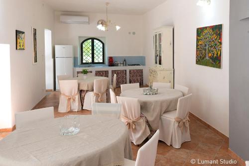 ein Esszimmer mit 2 Tischen und weißen Stühlen in der Unterkunft Piccolo Albergo del Musicista in Ventaroli