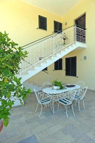 a patio with a table and chairs and a staircase at Casa Vacanze La Mattonara in Viterbo