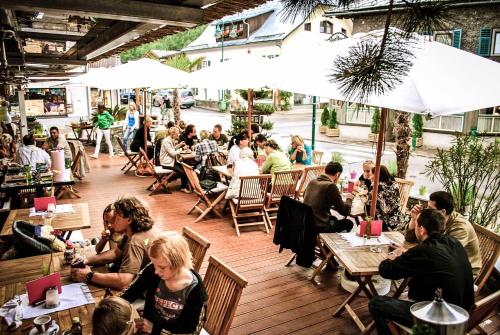 a group of people sitting at tables in a restaurant at Hotel Wintergarten in Schladming