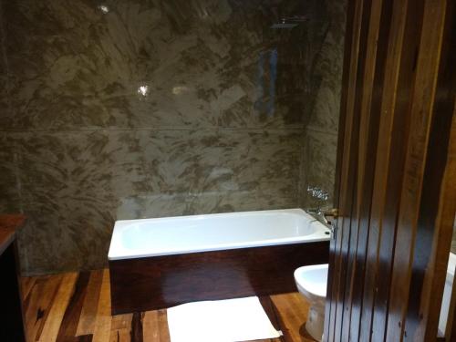 a bathroom with a bath tub and a toilet at La Mision Mocona - Lodge de Selva in Saltos del Moconá