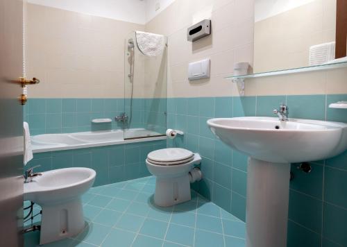 a bathroom with a toilet, sink and tub at Hotel Achibea in San Vito lo Capo