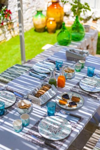 a blue table with plates of food on it at Hermanas Relais - trulli luxury in Alberobello