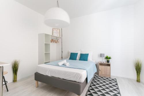 um quarto com uma cama com almofadas azuis em RELAXING 95m² DUPLEX APPARTEMENT 3 Chambres em Béziers