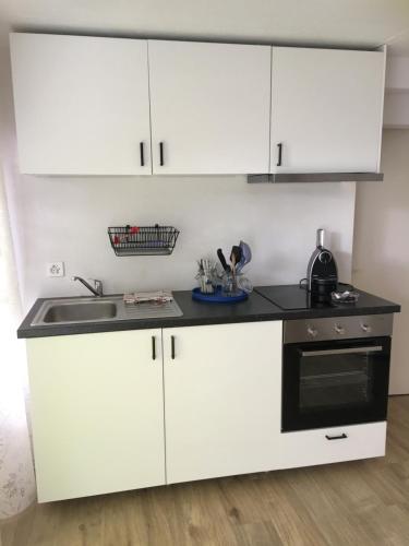 a kitchen with white cabinets and a black oven at Christall in Andest