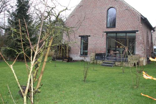 a brick house with a window and a yard at Logies Tommenmolen in Grimbergen