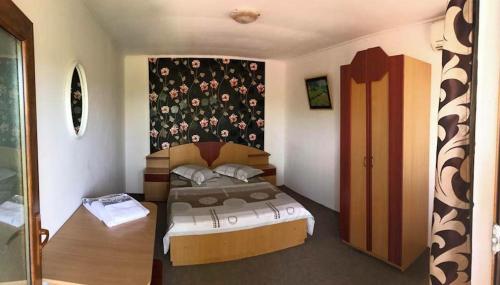 a bedroom with a bed and a wall with flowers at Casa Lenuta in Mila Douăzeci şi Trei