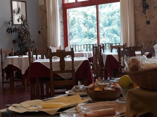 a dining room with tables and chairs and a window at MONASTERIO de SANTA MARÍA DE VALVANERA in Anguiano