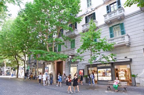 Un gruppo di persone che camminano per una strada di fronte a un edificio di La Dimora Luca Giordano a Napoli