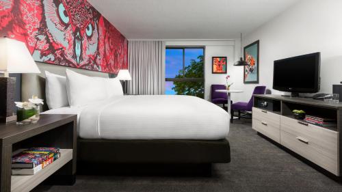 a hotel room with a bed and a television at Studio Allston Hotel Boston in Boston