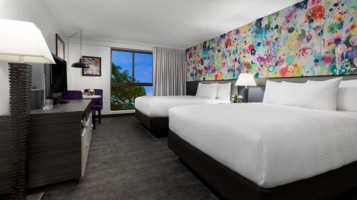 a hotel room with two beds and a large window at Studio Allston Hotel Boston in Boston