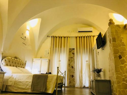 een slaapkamer met een bed in een kamer met een boog bij 26 Suite Home in Ostuni
