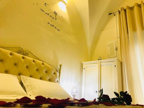 een slaapkamer met een bed met een gouden hoofdeinde en een opschrift aan de muur bij 26 Suite Home in Ostuni