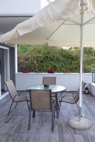 a table and chairs with an umbrella on a patio at Blue4Aqua Apartments in Kavala