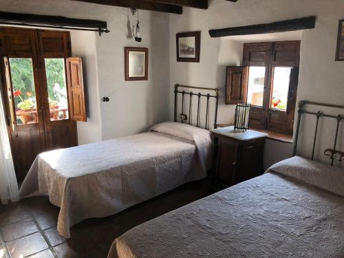 BorgeにあるHotel Posada del Bandoleroのベッドルーム1室(ベッド2台、窓付)