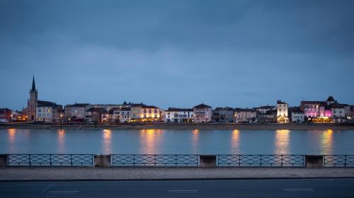 a large body of water with buildings in the background at Hôtel du Nord in Mâcon