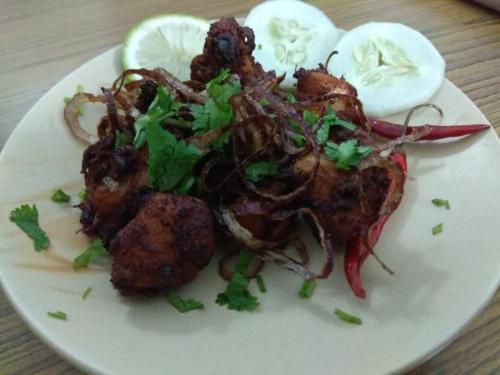 a plate of food with meat and eggs on a table at Latei Ville Inn in Shillong