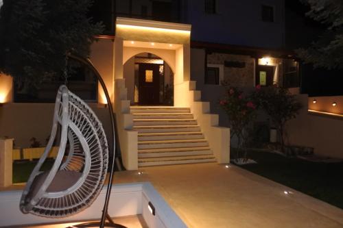 a house with a white fan and stairs at night at Hotel Konaki in Arnaia