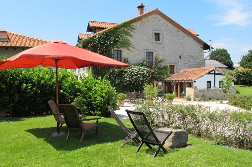 a group of chairs and an umbrella in a yard at Casona Camino de Hoz in Anero