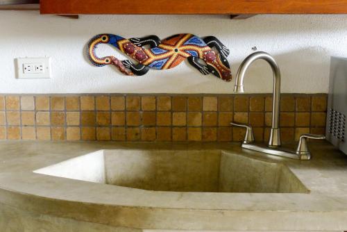 a sink in a kitchen with a mask on the wall at Luxury Studio Apartment with all the Trimmings in San Juan del Sur