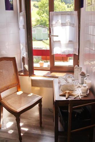 une table et une chaise dans une pièce avec une fenêtre dans l'établissement Chez Marraine, à Sauvat