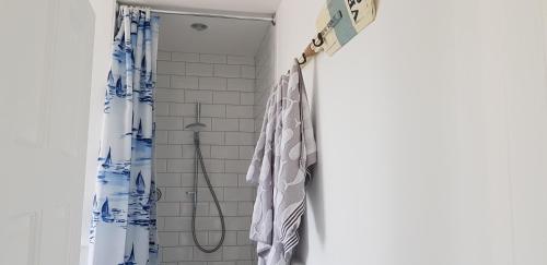 ducha con cortina azul y blanca en Tidal View, en Kincasslagh