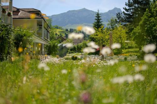 a field of flowers in front of a house at Resort Hof Weissbad in Weissbad