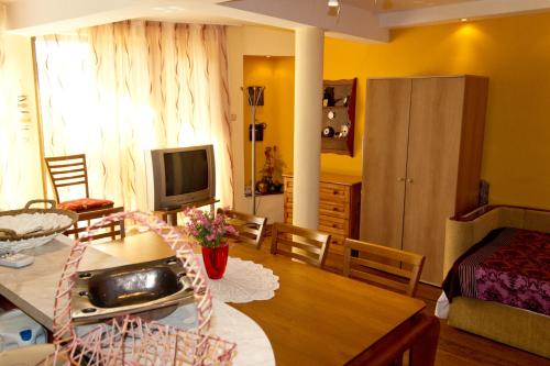 a kitchen and living room with a table and a television at Guest House Prodanov in Sozopol