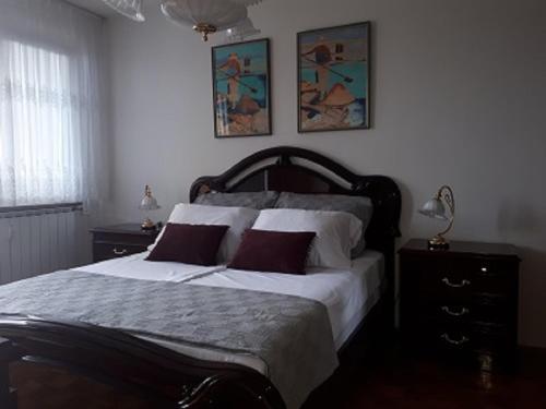 a bedroom with a large bed with white sheets and red pillows at Apartma Lilu in Koper