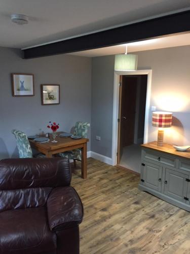 a living room with a couch and a table at Ridgewood Apartment in Drumnadrochit