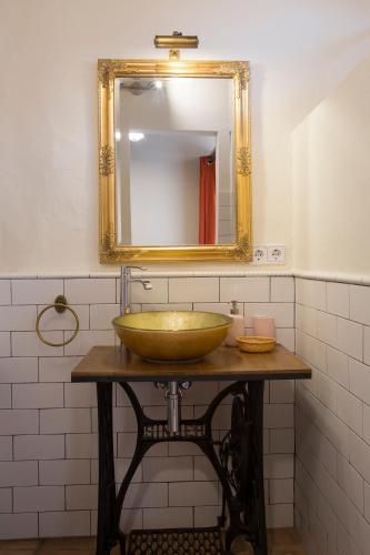 a bathroom with a gold sink and a mirror at Mas Tomas in Vall-Llobrega