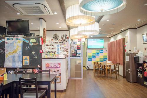 un restaurante con comedor con mesas y sillas en HOSTEL WASABI Nagoya Ekimae, en Nagoya