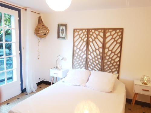 a bedroom with a white bed and a window at Villa Akwaba in Pyla-sur-Mer
